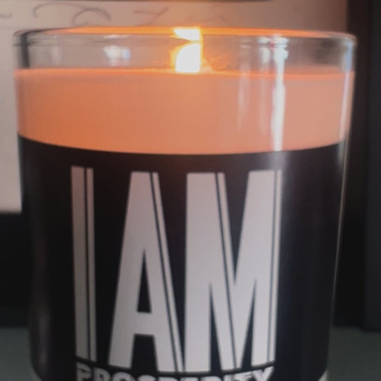 White soy wax candle in a glass vessel. Black label with the affirmation "I am Prosperity" in white aesthetic text. 